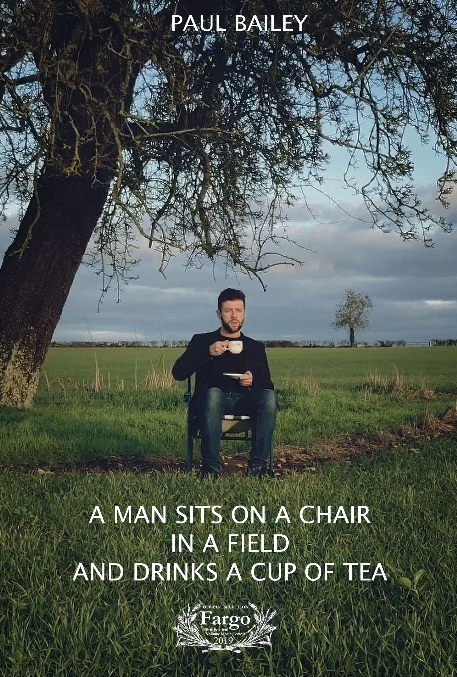 A Man Sits on a Chair in a Field and Drinks a Cup of Tea